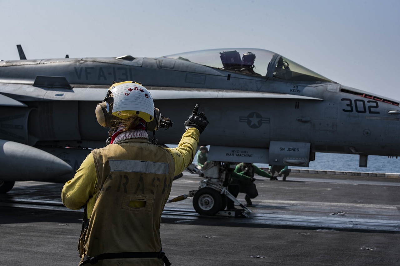 Petty Officer 3rd Class Gabrielle Embry signals to an F/A-18F Super Hornet, assigned to Strike Fighter Squadron (VFA) 131, on the flight deck of the aircraft carrier USS Dwight D. Eisenhower (CVN 69) (Ike). Embry serves as an aviation boatswain’s mate (handling) aboard Ike. Ike and its carrier strike group are deployed in support of Operation Inherent Resolve, maritime security operations and theater security cooperation efforts in the U.S. 5th Fleet area of operations.  U.S. Navy photo/Petty Officer 3rd Class Nathan T. Beard 
