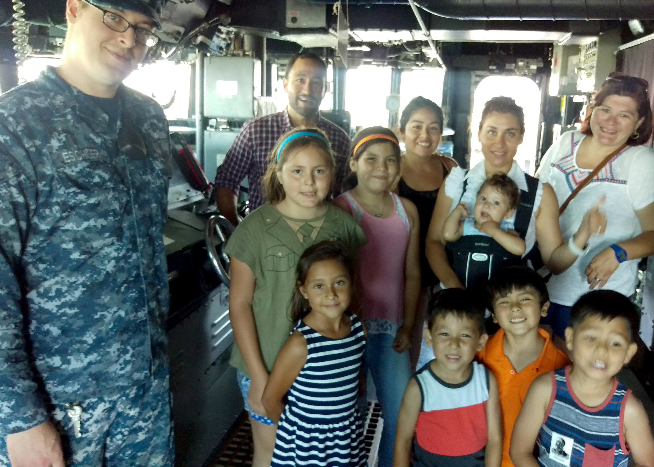 Naval Information Forces West provided a tour of the Naval Base San Diego to local students and their parents July 22.  The families belong to the Marlow B. Martinez Foundation, a local non-profit organization supporting disadvantaged children. A member of the USS Sampson DDG 102 crew took time to pose for a group photo. U.S. Navy photo by LCDR Henry A. Martinez.