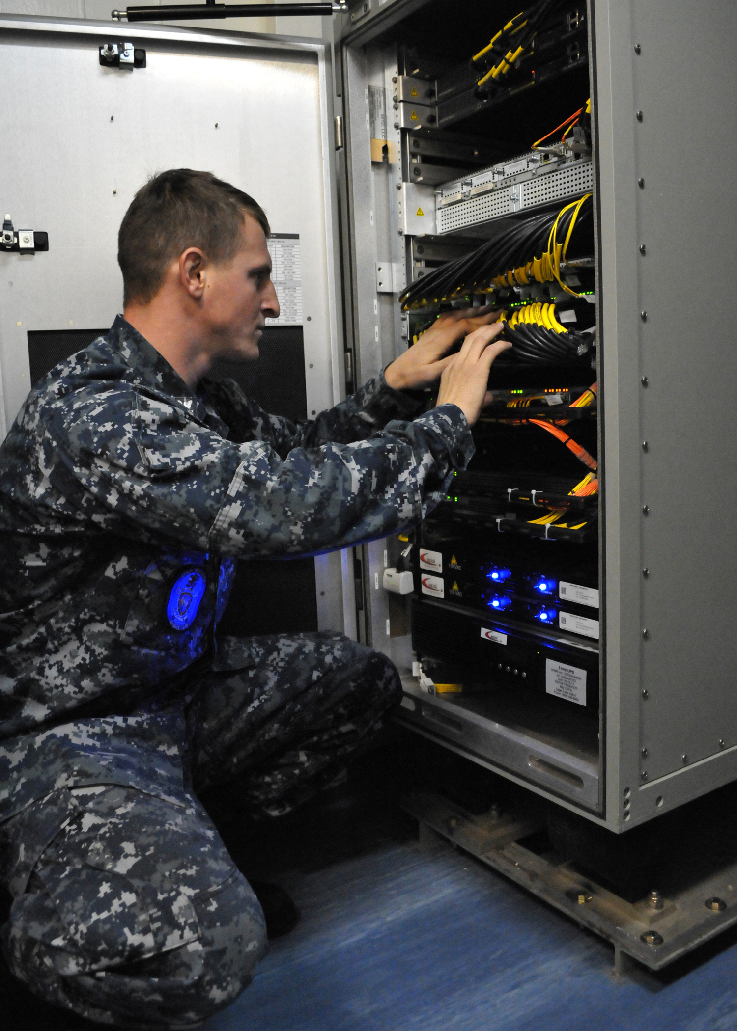 SAN DIEGO (Nov. 19, 2013) Information Systems Technician 2nd Class Anthony Pisciotto checks network connectors on the recently installed Consolidated Afloat Ships Network Enterprise Services (CANES) system in the close confines of the Local Area Network (LAN) Equipment Room aboard the guided missile destroyer USS Milius (DDG 69). U.S. Navy photo by Rick Naystatt.