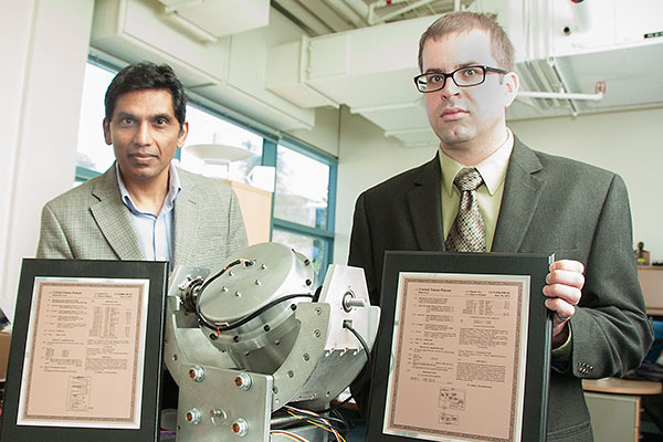 Naval Postgraduate School professor Mike Ross, left, and research associate professor Mark Karpenko, right, are pictured with their recently issued patent certificates for their invention, "Method and Apparatus for Contingency Guidance of a CMG-actuated Spacecraft." The invention provides a new approach for maneuvering satellites in space. The professors' patent was among 393 patents the Department of the Navy received from the U.S. Patent and Trademark Office in fiscal year 2015. U.S. Navy photo by Javier Chagoya 