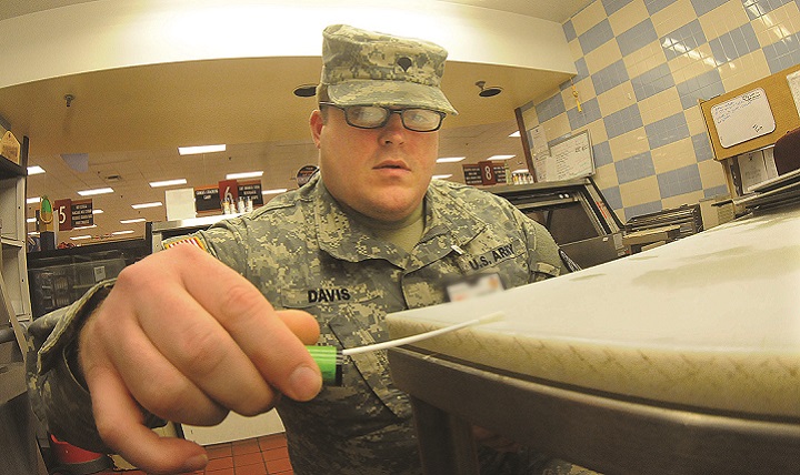 Army Spc. Tyler Davis, Fort Lee Veterinary Services, uses a swab to test a food preparation area for bacteria at the Defense Commissary Agency store here recently. Davis, a veterinary food inspection specialist, is part of the effort that ensures food safety and security on installations all over the world. (U.S. Army photo by T. Anthony Bell)