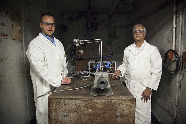 INDIAN HEAD, Md. (May 5, 2015) Dr. Vasant Joshi, a senior materials scientist in the Explosive Ordnance Disposal Technology Division at Naval Surface Warfare Center Indian Head, and Dr. Greg Young, propulsion engineer and program lead, show the sub-scale rocket motor test stand constructed to demonstrate their work on hybrid rocket propulsion. Young and Joshi received the Dr. Delores M. Etter Award for Top Scientists and Engineers from the office of the assistant secretary of the Navy for research, development, and acquisition. U.S. Navy photo by Matthew Poynor.
