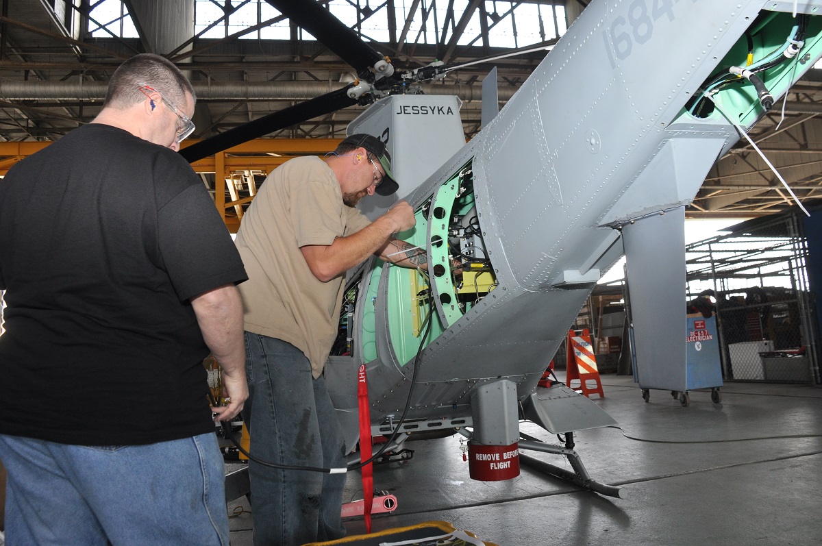 Aircraft electrician Kevin Fishel, right, and avionics electrician Scott McClure install antennae cable in an MQ-8B Fire Scout UAV in the HSC-23 hangar aboard Naval Air Station North Island. 

