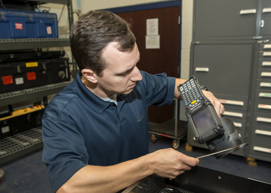 Dustin Barnes, a research analyst with Innovative Professional Solutions, Inc., scans Radio Frequency Identification Device (RFID) tags attached to tools as part of an inventory demonstration. The tags are part of the Mission Package Automated Inventory Information System (MPAIIS) which reduces inventory labor costs. The system, developed at Naval Surface Warfare Center Panama City Division (NSWC PCD), recently received authority to operate by U.S. Navy standards. Photo by Ron Newsome, NSWC PCD.