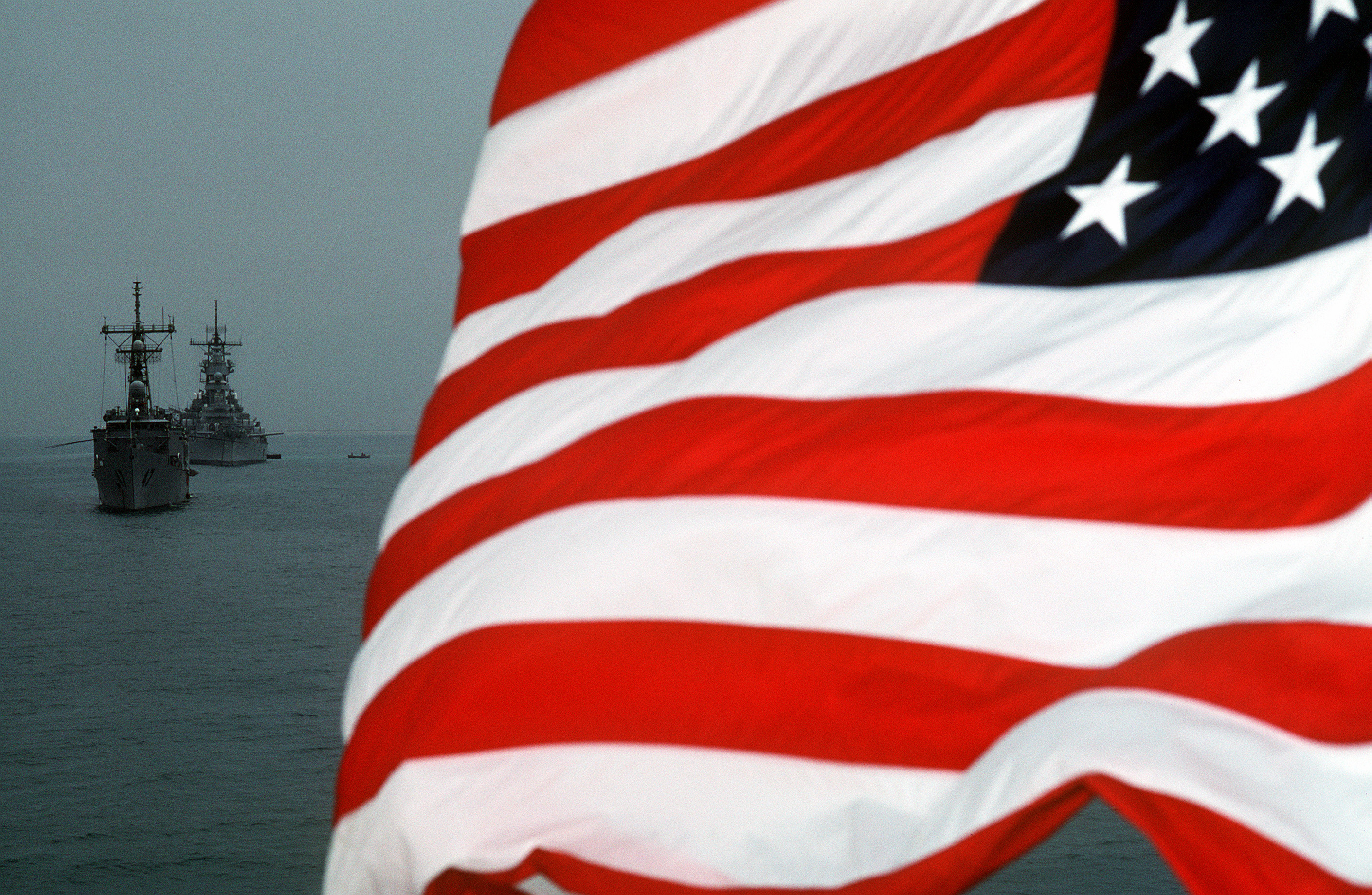 The national ensign flies from the stern of a U.S. Navy ship at anchor in the Persian Gulf region during Operation Desert Storm. Photo courtesy of U.S. Navy.