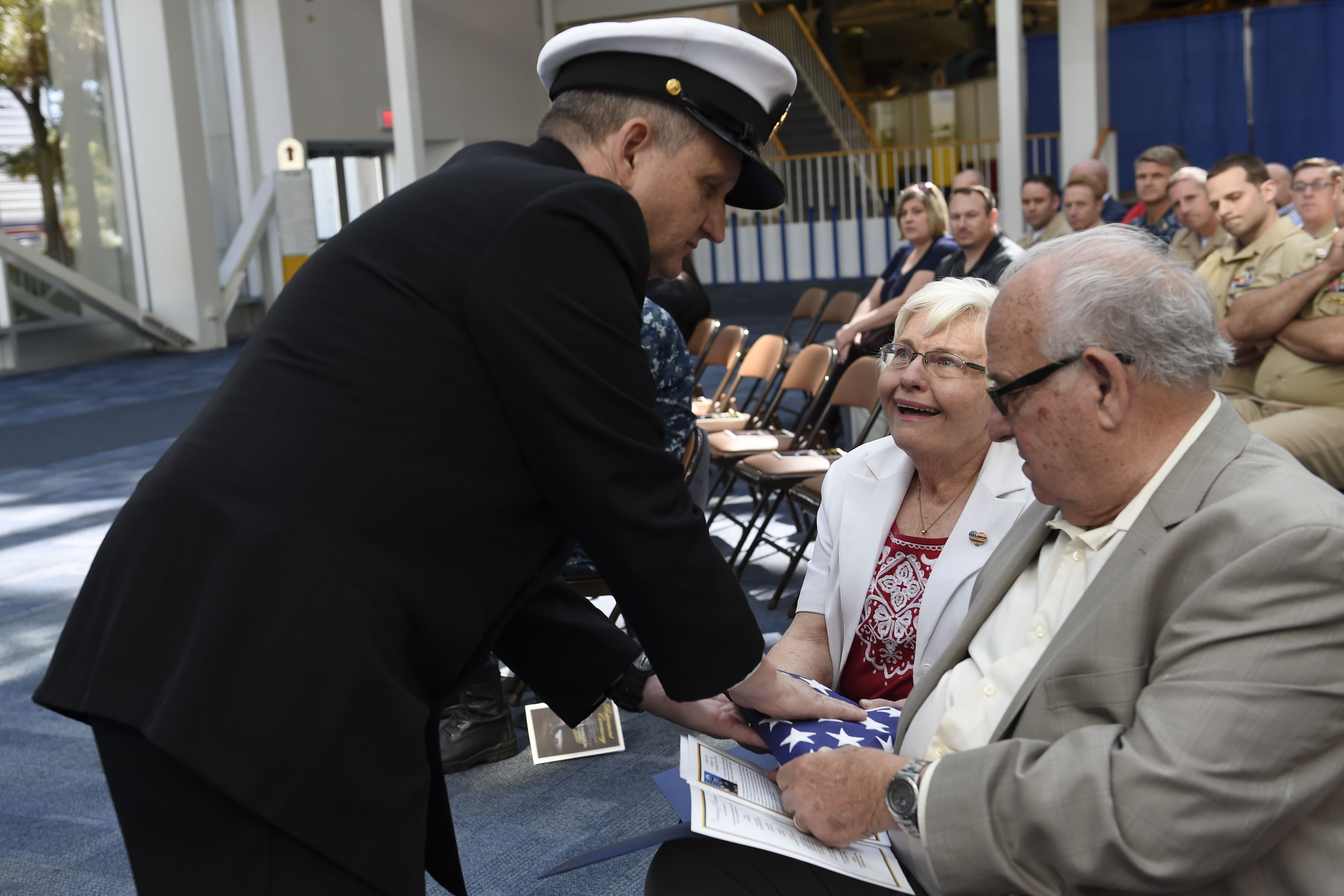 PENSACOLA, Fla. (Oct. 21, 2016) Master Chief Petty Officer Frank Carollo presents a folded flag to his mother, Patricia Carollo, during his retirement ceremony at the National Naval Aviation Museum at Naval Air Station Pensacola. The ceremony commemorated the end of Carollo's 33 years of naval service. U.S. Navy photo by Petty Officer 3rd Class Taylor L. Jackson.