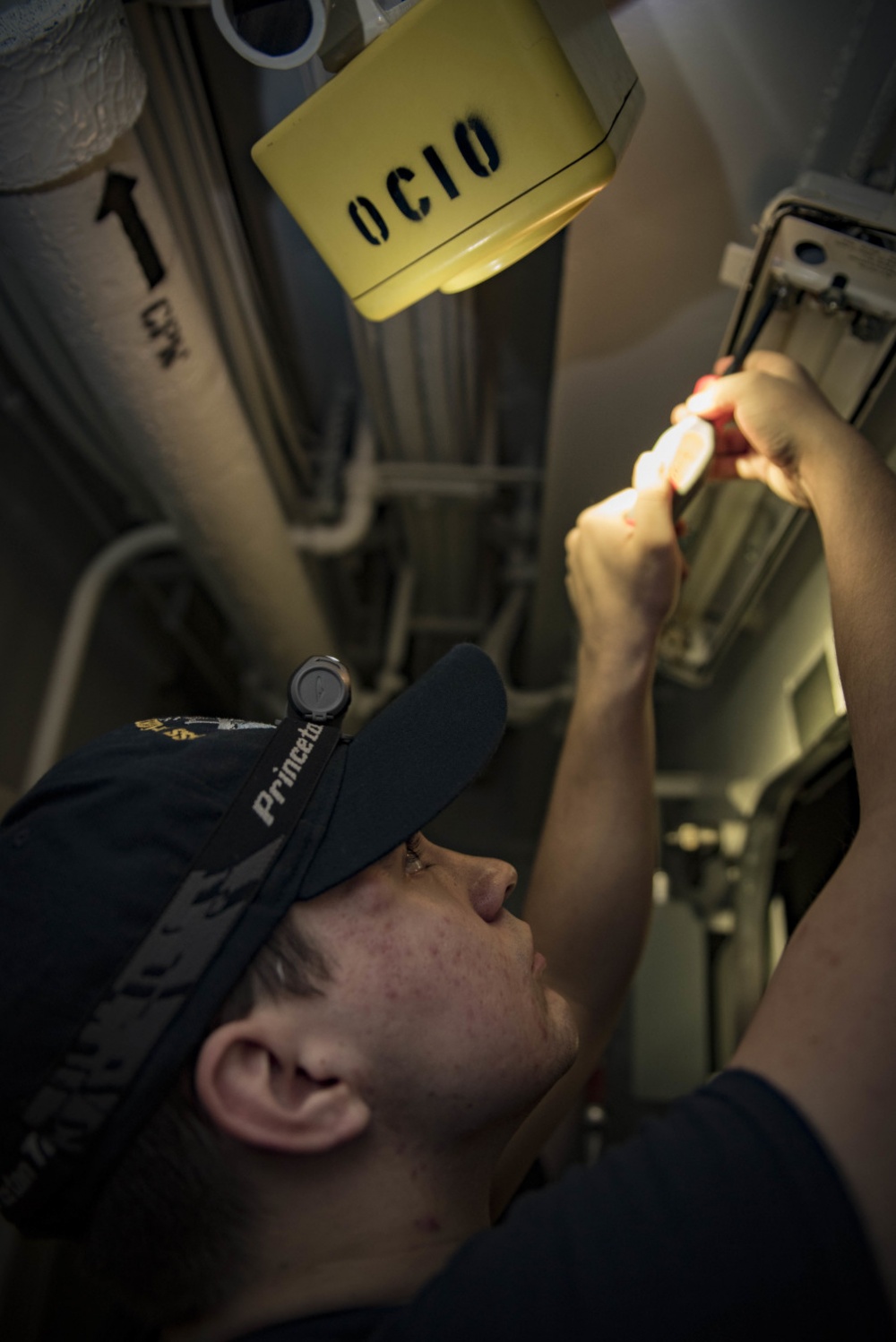 ARABIAN GULF (Aug. 19, 2016) Fireman Nikolas Martin, from Joplin, Mo., converts a light fixture to use energy-efficient LED bulbs in a passageway aboard the aircraft carrier USS Dwight D. Eisenhower (CVN 69) (Ike) as part of the ship’s Great Green Fleet initiative. Ike and its Carrier Strike Group are deployed in support of Operation Inherent Resolve, maritime security operations and theater security cooperation efforts in the U.S. 5th Fleet area of operations.  U.S. Navy photo by Mass Communication Specialist Seaman Apprentice Joshua Murray 