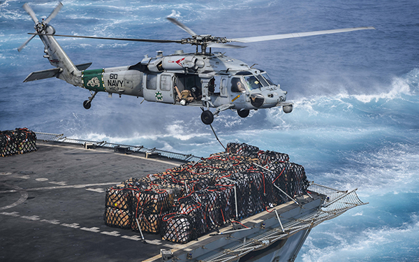 A Navy MH-60S Sea Hawk helicopter assigned to Helicopter Sea Combat Squadron 7 prepares to deliver cargo to the flight deck of the aircraft carrier USS Dwight D. Eisenhower during a replenishment-at-sea with the fast-combat support ship USNS Arctic. Ike and its Carrier Strike Group were deployed in support of Operation Inherent Resolve. Navy photo by Mass Communication Specialist Seaman Christopher Michaels

