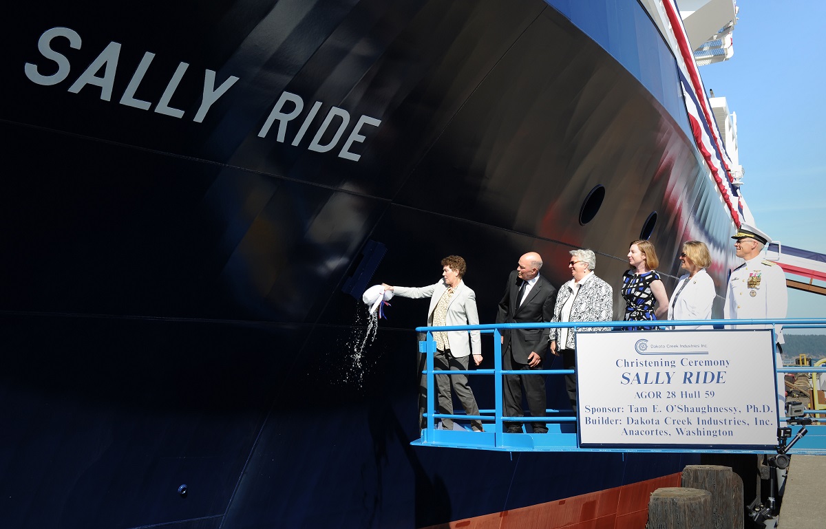 ANACORTES, Wash. (Aug. 9, 2014) Dr. Tam O'Shaughnessy, ship's sponsor for the auxiliary general oceanographic research (AGOR) vessel R/V Sally Ride (AGOR 28), breaks a bottle across the bow during a christening ceremony at the Dakota Creek Industries, Inc., shipyard in Anacortes, Wash. Joining O'Shaughnessy on the platform are Mr. Dick Nelson, president, Dakota Creek Industries, Inc., Matron of Honor, the reverend Dr. Bear Ride, Matron of Honor, Kathleen Ritzman, assistant director, Scripps Institution of Oceanography, University of California San Diego, Kathryn Sullivan, undersecretary of commerce for oceans and atmosphere and administrator, National Oceanic and Atmospheric Administration, and Rear Adm. Matthew Klunder, chief of naval research. U.S. Navy photo by John F. Williams/Released