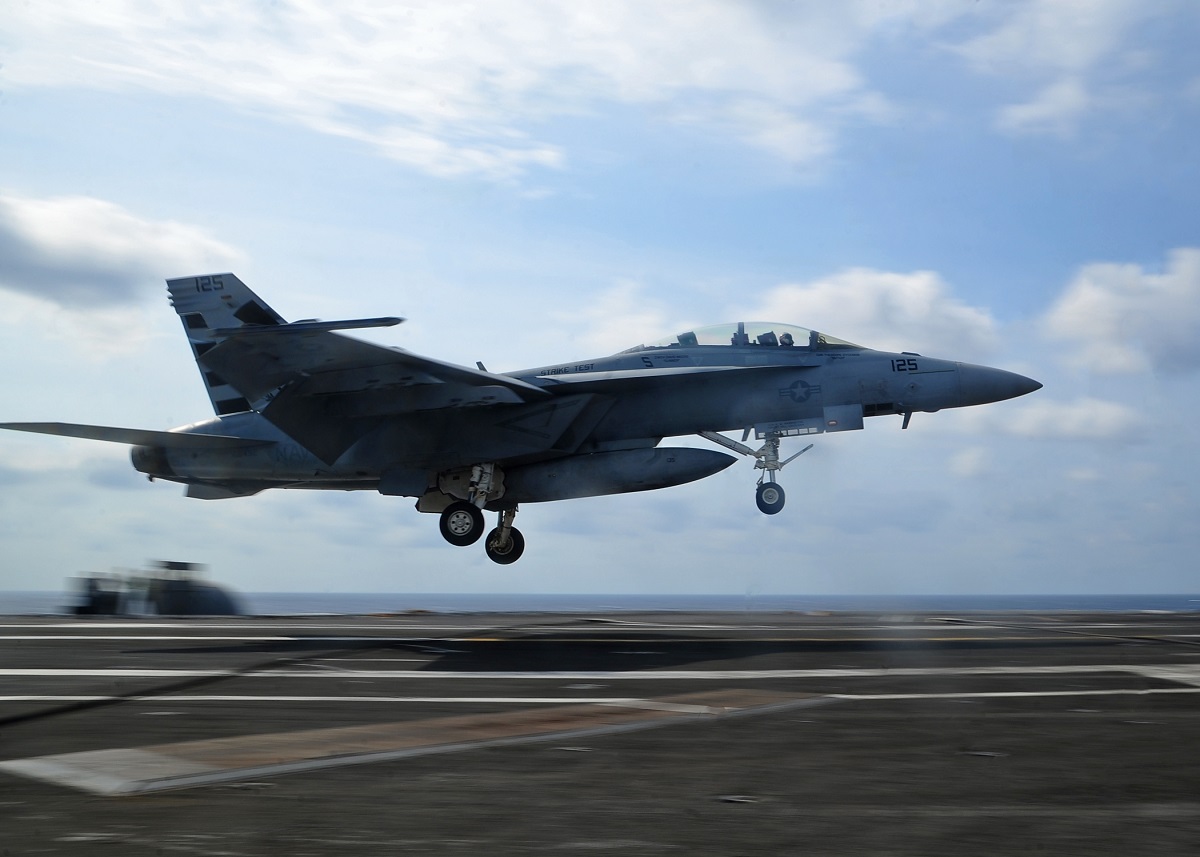 F/A-18F Super Hornet from Air Test and Evaluation Squadron (VX) 23 performs a touch-and-go on the flight deck of the aircraft carrier USS George Washington (CVN 73). The squadron is conducting tests of the Maritime Augmented Guidance with Integrated Controls for Carrier Approach and Recovery Precision Enabling Technologies (MAGIC CARPET), which will provide improved safety, efficiency and success rates in recovering fixed-wing aircraft on board aircraft carriers. Washington, homeported in Norfolk, is underway conducting carrier qualifications in the Atlantic Ocean. U.S. Navy photo by Mass Communication Specialist Seaman Clemente A. Lynch/Released 