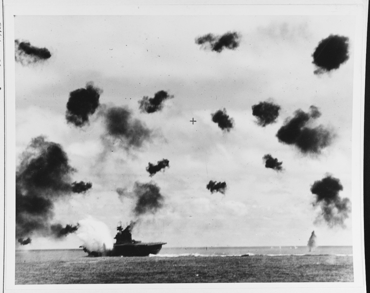 USS Yorktown (CV-5) is hit on the port side, amidships, by a Japanese Type 91 aerial torpedo during the mid-afternoon attack by planes from the carrier Hiryu, 4 June 1942. Photographed from USS Pensacola (CA-24). Yorktown is heeling to port and is seen at a different aspect than in other views taken by Pensacola, indicating that this is the second of the two torpedo hits she received. Note very heavy anti-aircraft fire. Official U.S. Navy Photograph, now in the collections of the National Archives