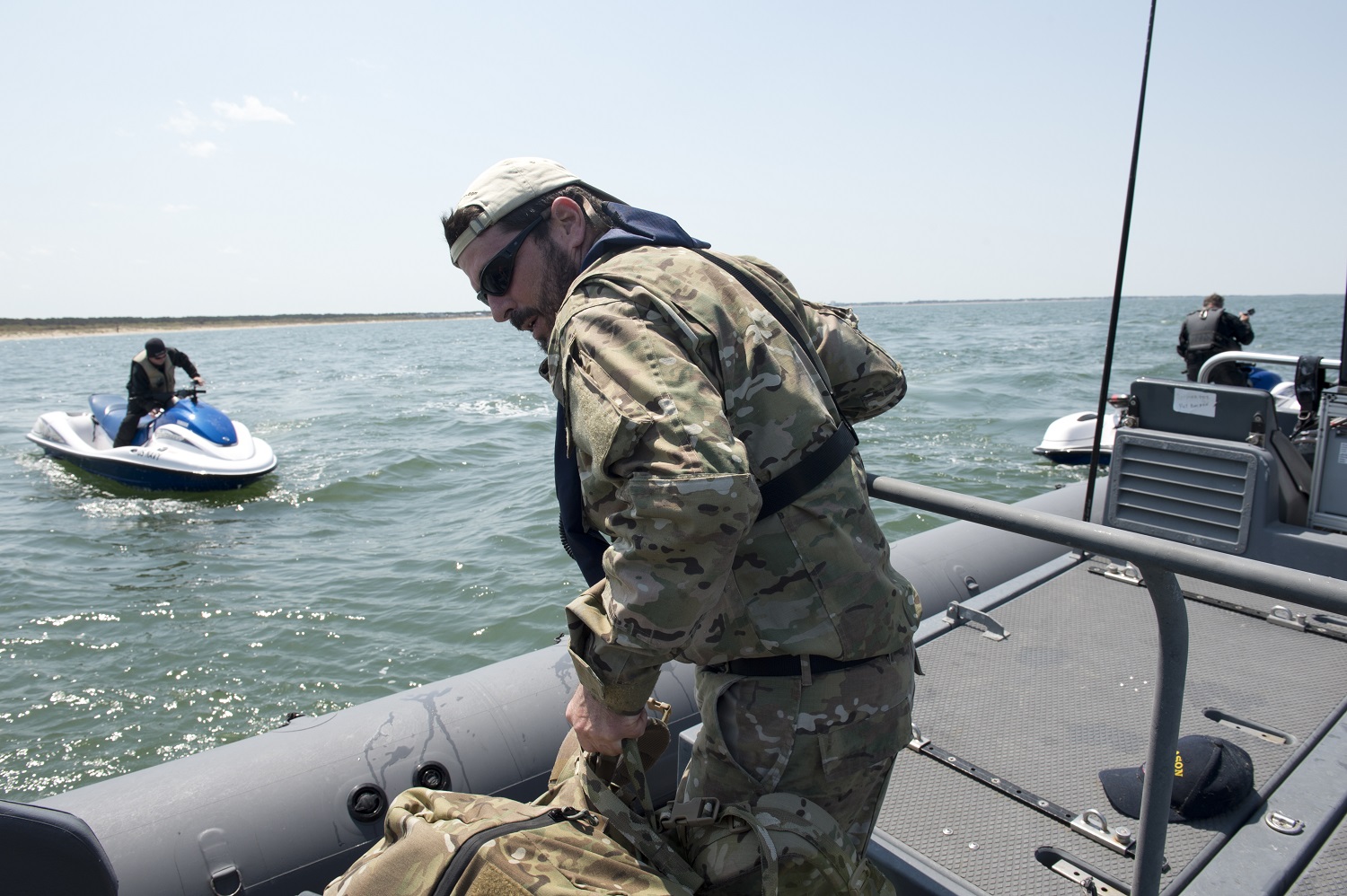 Operations Advisor Don Behr prepares to be transported from an 11-meter rigid-hull inflatable boat to a jet-ski operated by Seaward Services Boat Capt. Sam Calabese during a high-value target interdiction scenario on the beach off the coast of Virginia Beach, Va., April 22, 2015. Over two weeks in April, CNO’s Rapid Innovation Cell and Stiletto personnel along with system developers tracked Behr as a simulated target of interest from the Stiletto’s Command Information Center to assess adaptive force packages and new concepts for command and control and multi-sensor fusion technologies for smaller vessels. U.S. Navy photo by Nicholas Malay.