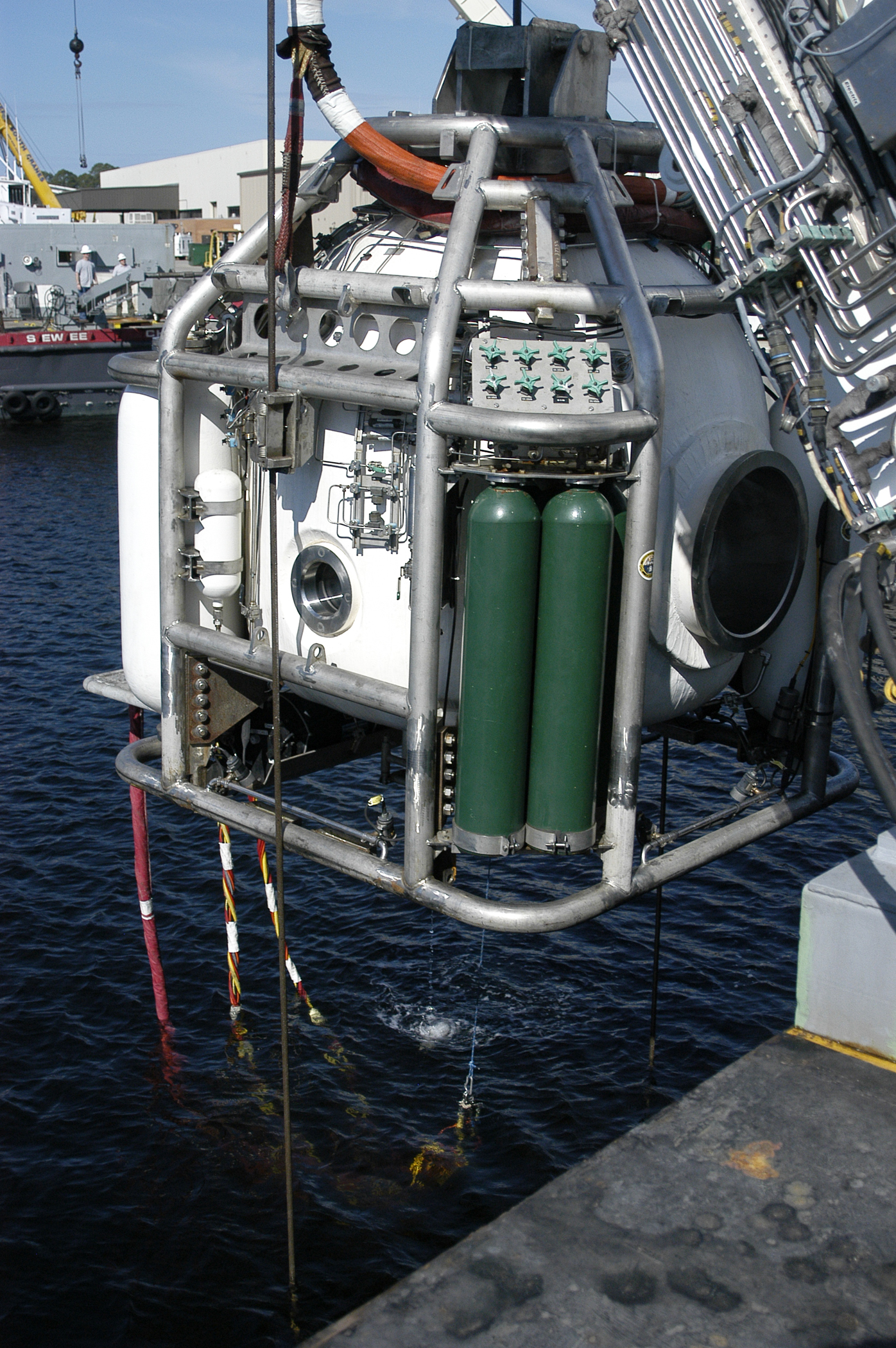 The fly away saturation system, or SATFAD, dive bell moves from the deck of a barge in Panama City, Florida March 10, 2015 into the water where U.S. Navy saturation divers conduct pier-side training operations. The training allowed the specialized set of Navy divers to retain qualifications, and hone skills. Photo by Jacqui Barker/NSWC PCD.