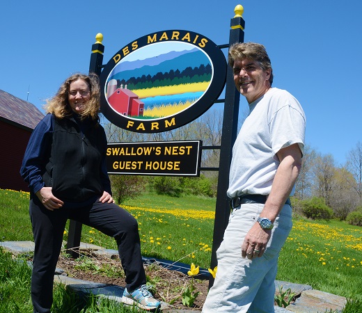 Lyn and Jim Des Marais of Brandon, Vermont stand next to a sign on their 1,250 acre farm in the Otter Creek Watershed.