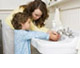 	mom helping boy wash hands at sink