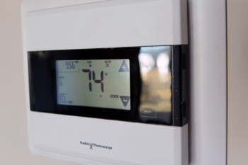 A digital programmable thermostat set for energy savings during the heating season can save energy and money. | Photo courtesy of Thomas Kelsey/U.S. Department of Energy Solar Decathlon