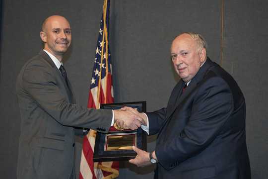 Derek Estes accepts his award from former NNSA Administrator Linton Brooks. 