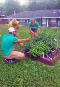 Derek Franklin works with a Village 76 resident and Green Thumb Intern Kaitlyn Meyer to check the health of the "veggie squares," personal gardens created for residents.