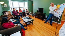 EI2 field staff explain the assessment and upgrade process at a house party