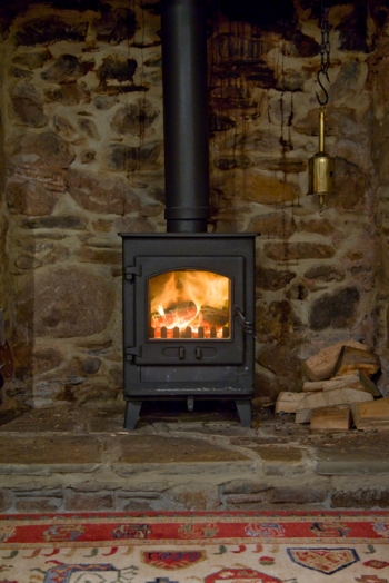 A wood stove on a stone hearth. | Photo courtesy of Â©iStockphoto/King_Louie