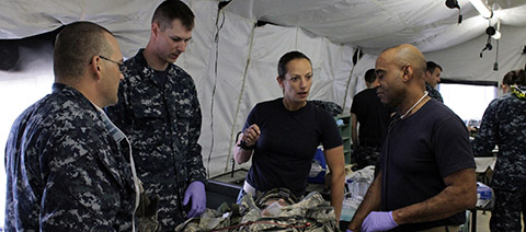 Lt. Hillary Brainard, and Capt. Edwin Turner, Emergency Room Department Head discuss a patient’s condition with Sailors attached to Expeditionary Medical Force One during Operation Northern Lights.