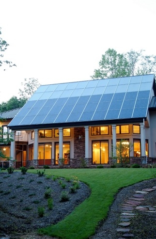 This North Carolina home gets most of its space heating from the passive solar design, but the solar thermal system (top of roof) supplies both domestic hot water and a secondary radiant floor heating system. | Photo courtesy of Jim Schmid Photography.
