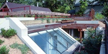 Photo of an earth-sheltered home with skylights and landscaping on the roof.