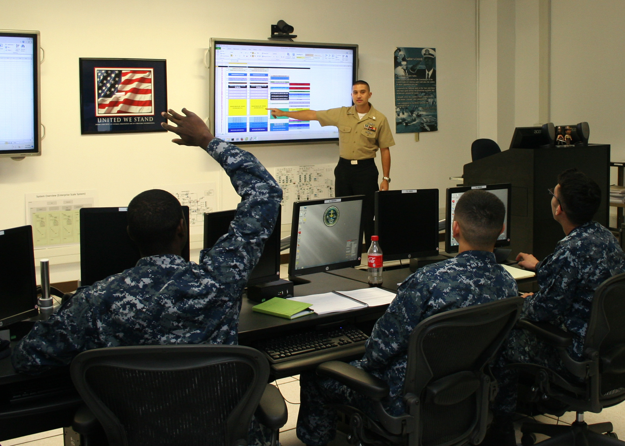 A Consolidated Afloat Networks and Enterprise Services (CANES) instructor discusses equipment layout with students during CANES "C" school at Information Warfare Training Command (IWTC) Virginia Beach. U.S. Navy photo by Petty Officer 2nd Class Jay Teerlink.