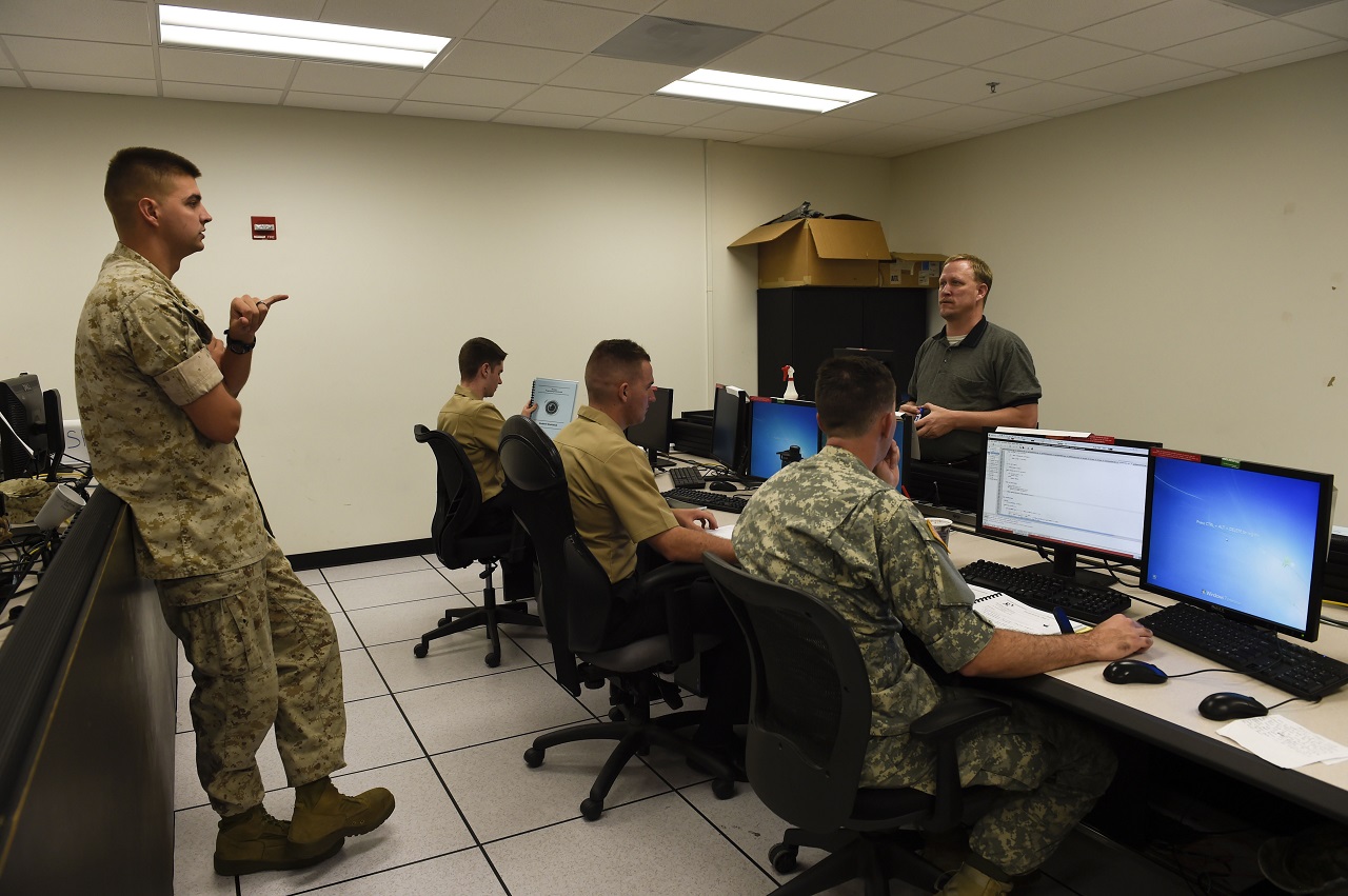 PENSACOLA, Fla. (Oct. 21, 2016) Marine Sgt. Jeremy Scott asks a question to Brion Lang, an instructor for the Joint Cyber Analysis Course (JCAC), during an independent study session at Information Warfare Training Command Corry Station. JCAC trains enlisted personnel from all services in the skills and knowledge to perform technical network analysis in cyberspace operations.  U.S. Navy photo by Petty Officer 3rd Class Taylor L. Jackson/Released