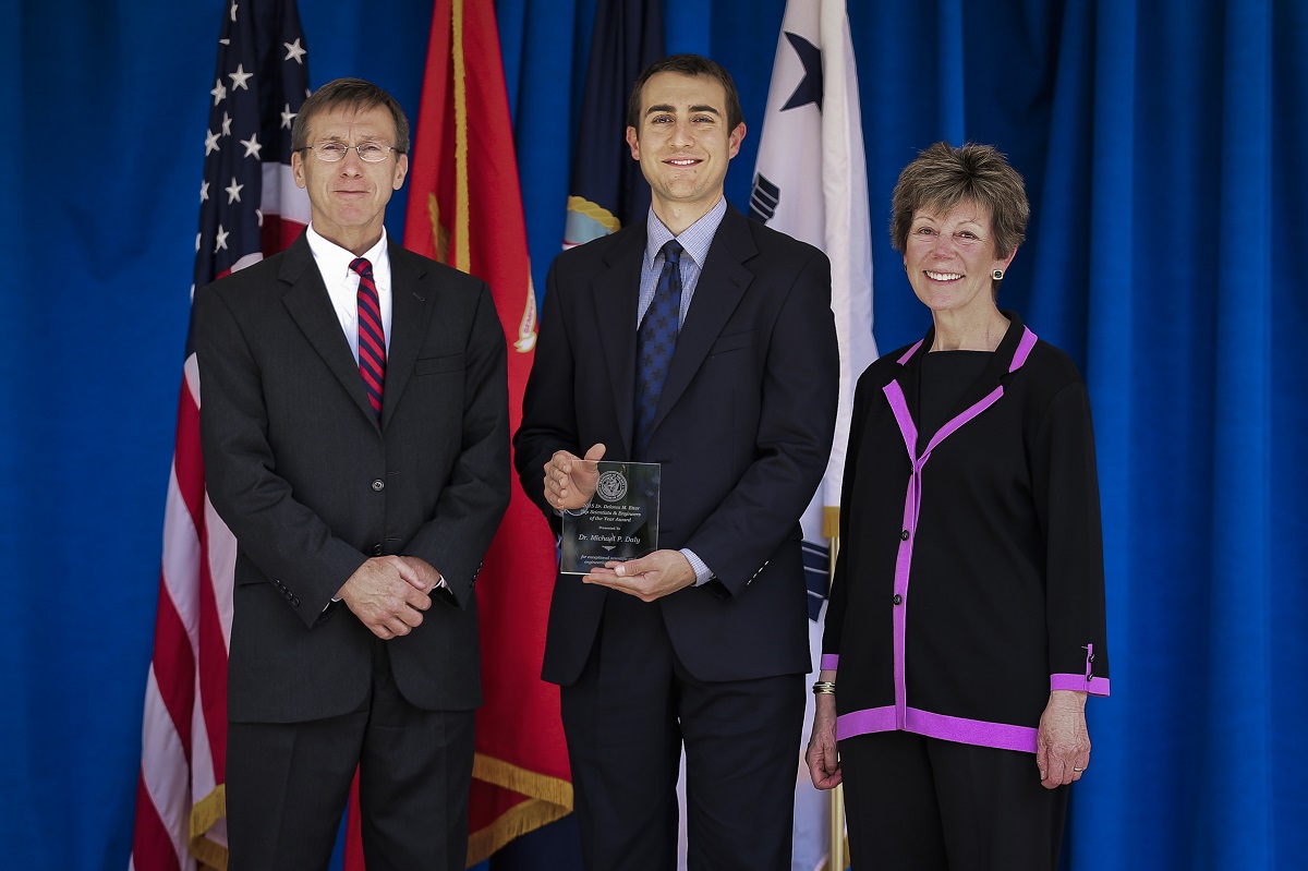 Sean Stackley, assistant secretary of the Navy for Research, Development and Acquisition and Dr. Delores Etter, present Michael Daly with the 2015 Dr. Delores M. Etter Top Scientists & Engineers of the Year Award. U.S. Navy photo by Matthew Poynor, Naval Surface Warfare Center Indian Head Explosive Ordnance Disposal Technology Division