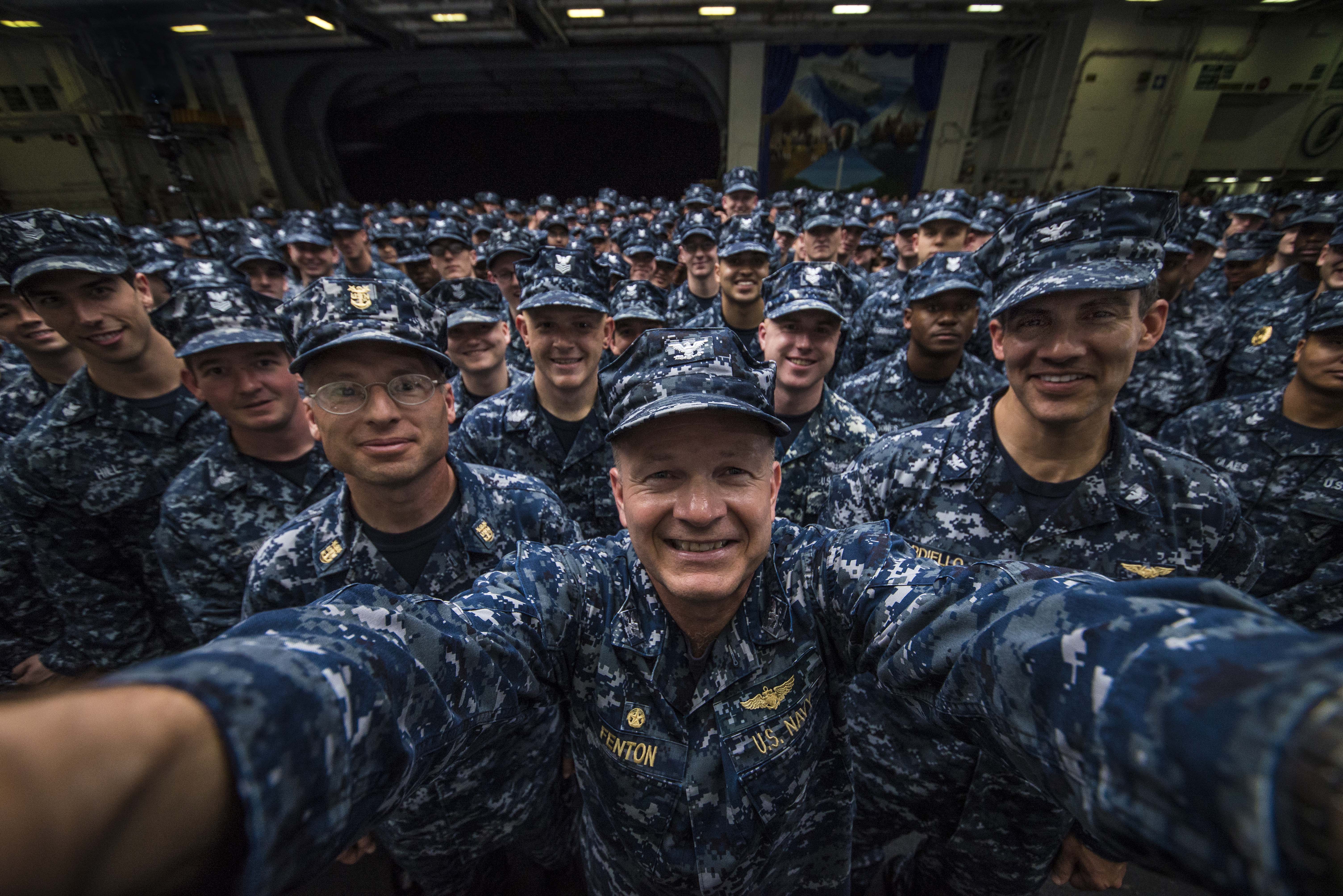 PACIFIC OCEAN (May 30, 2014) Capt. Greg Fenton, commanding officer of the aircraft carrier USS George Washington (CVN 73), center, takes a selfie with Capt. Carlos Sardiello, George Washington's executive officer, right, George Washington's Command Master Chief Shaun Brahmsteadt and 275 newly frocked petty officers after a command frocking ceremony in the ship's hangar bay. George Washington and its embarked air wing, Carrier Air Wing (CVW) 5, provide a combat-ready force that protects and defends the collective maritime interests of the U.S. and its allies and partners in the Indo-Asia-Pacific region. U.S. Navy photo by Capt. Greg Fenton.