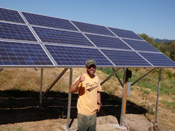 Michael Paine stands in front of a recently installed solar array on his organic farm in Yamhill, Ore.