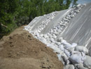 Construction of a berm to protect the Mni Wiconi Rural Water System raw water pump station. June 2011.