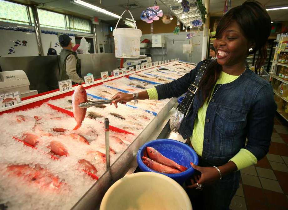 Devon Rutherford of Bridgeport shops for fresh fish at the International Farmers Market on Main Street in Bridgeport. Rutherford travels to the market twice a month by city bus. Photo: Brian A. Pounds / Connecticut Post