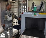 Centerra-SRS Security Police Officer performs an X-Ray inspection of items prior to admittance into a security area.