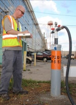 Neil Smith puts a trained eye on the pressure and flow of a food grade compound being injected into an underground plume of hazardous waste near the X-720 Maintenance Facility at the DOE Piketon Site. The sodium lactate compound promotes bacterial growth in the groundwater that turns hazardous waste into harmless end-products.