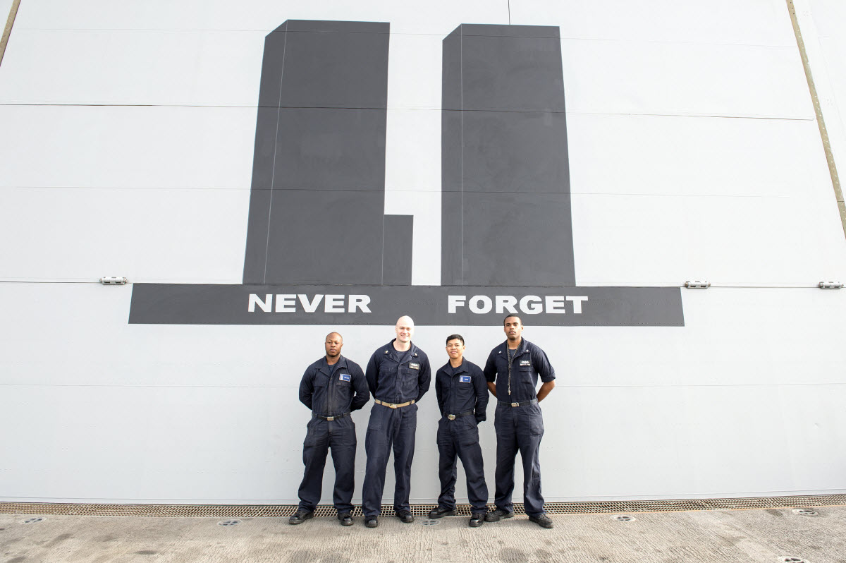 ARABIAN GULF (Feb. 20, 2015) Sailors pose for a photo in front of a mural painted of the Twin Towers of the World Trade Center on the hangar bay door aboard the amphibious transport dock ship USS New York (LPD 21). New York, part of the Iwo Jima Amphibious Ready Group, is deployed in support of maritime security operations and theater security cooperation efforts in the U.S. 5th Fleet area of responsibility. U.S. Navy photo by Mass Communication Specialist 3rd Class Jonathan B. Trejo.