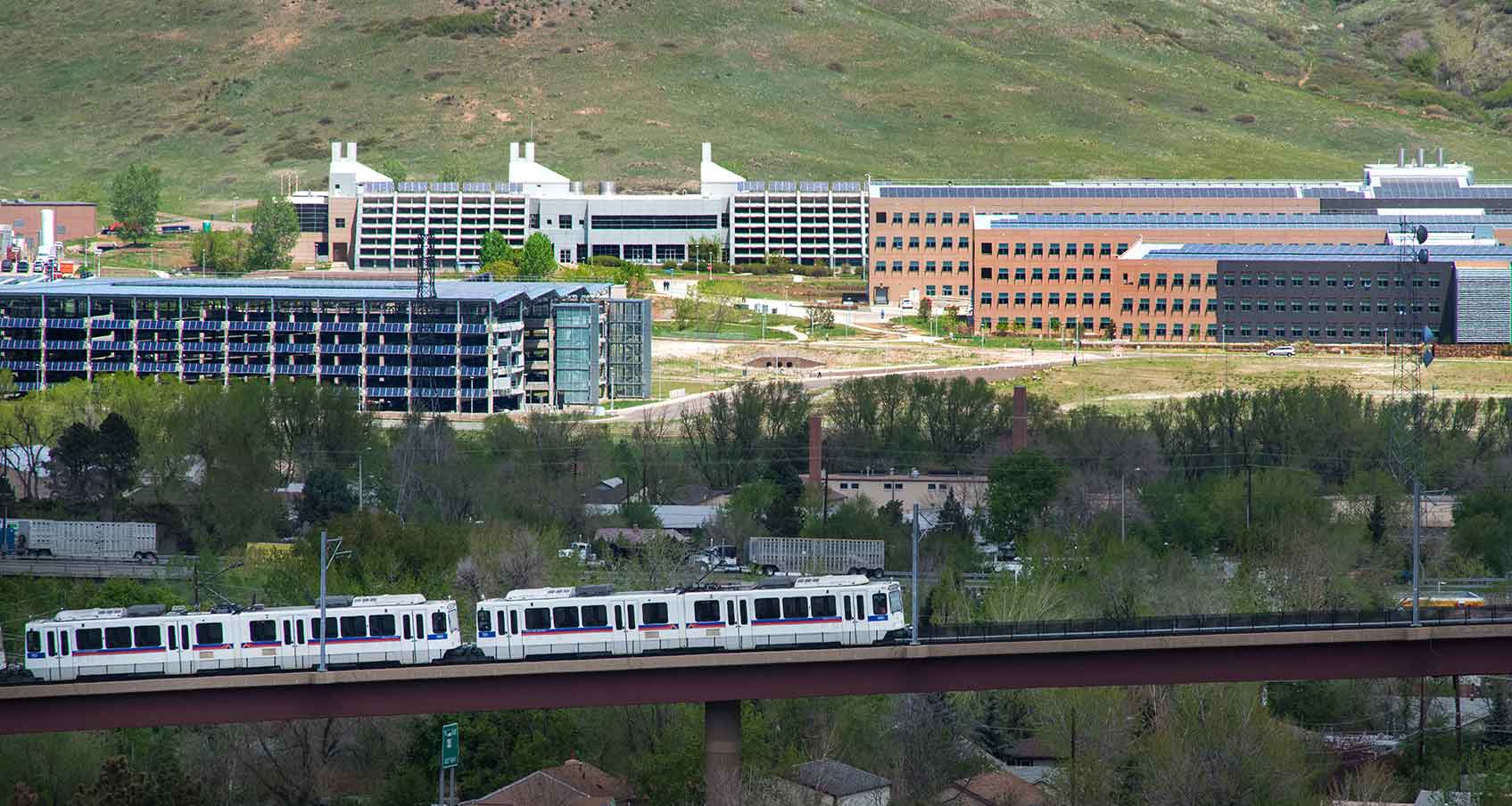 Photo of the light rail in the foreground and NREL’s South Table Mountain campus in the background. 