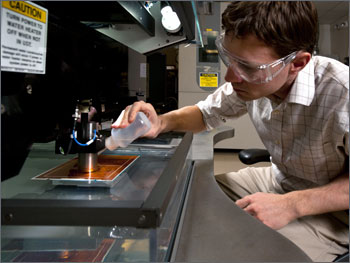 A photo of a researcher using testing equipment in a lab.