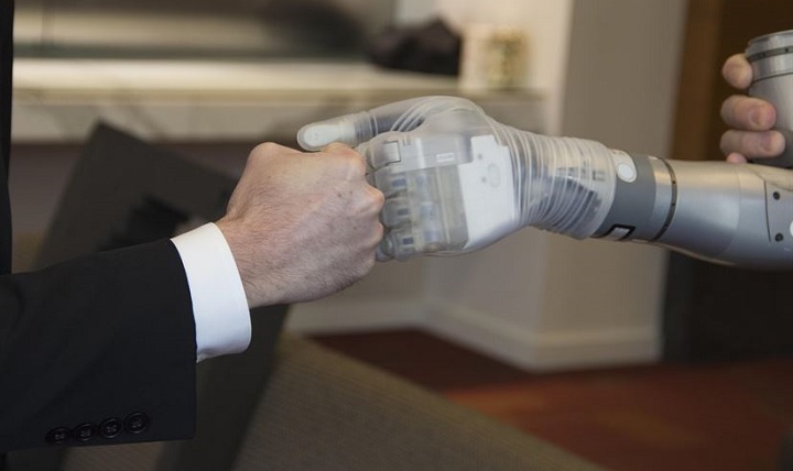 Dr. Justin Sanchez, director of the Defense Advanced Research Projects Agency’s Biological Technologies Office, fist-bumps with one of the first two advanced “LUKE” arms to be delivered from a new production line during a ceremony at Walter Reed National Military Medical Center in Bethesda, Maryland. 