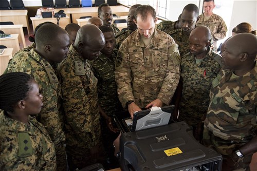 U.S. Army Sgt. Zechariah Dice, information operations course instructor, shows Uganda People’s Defense Force (UPDF) personnel how to use a tactical transmitter system during an information operations course at Jinja, Uganda, recently. Its use was part of a course designed to help the UPDF develop their ability to plan and disseminate information to civilians and violent extremist organizations to inform and reduce the need for force. (U.S. Air Force photo by Staff Sgt. Nathan Maysonet) 