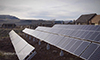 Photo of solar panels next to a log cabin