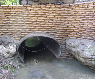 A nearly completed sand cement bag riprap wall.