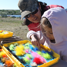 Little girl with mom choosing a fishing lure