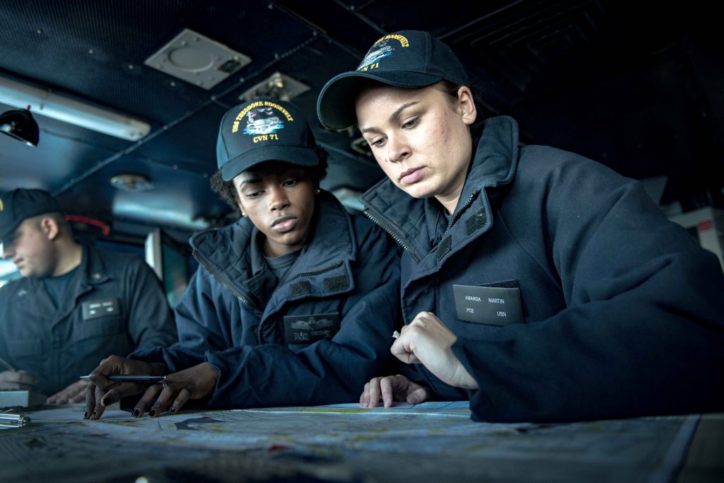 Petty Officer 2nd Class Amanda Martin and Petty Officer 3rd Class Tyleiah Strothers plot out a course in the pilot house of the aircraft carrier USS Theodore Roosevelt (CVN 71). (U.S. Navy photo by Seaman Bill M. Sanders/Released)