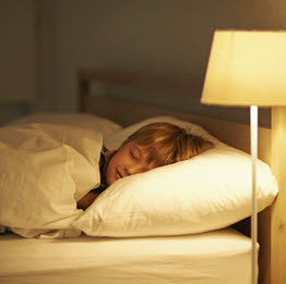 Sleeping child with a lamp on