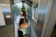 Dale Linkous carries pizza out of the walk-in freezer in the kitchen at the National Renewable Energy Laboratory in Golden, Colorado. The Energy Department <a href="http://energy.gov/articles/new-energy-efficiency-standards-commercial-refrigeration-equipment-cut-businesses-energy">announced new energy efficiency standards</a> for commercial freezers and refrigerators. | Photo by Dennis Schroeder, National Renewable Energy Laboratory 