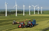 Farmers plowing fields near wind turbines (Copyright IStock).