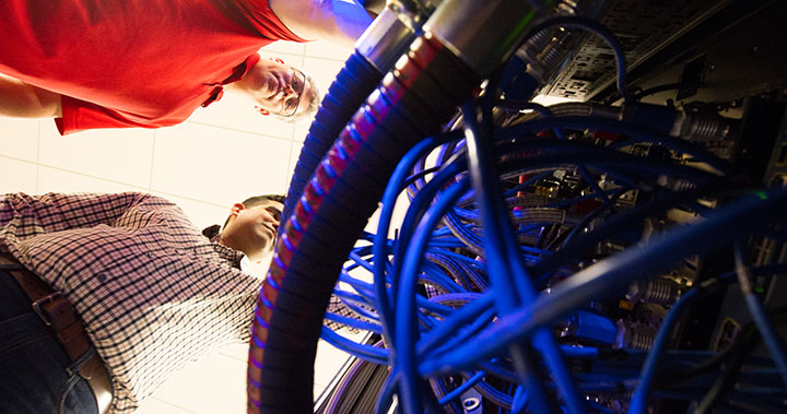 Photo of researchers working with liquid cooling hardware in a laboratory