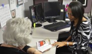 Photo:Jessica Etienne, a beneficiary services branch health care assistant who works in the Carl R. Darnall Army Medical Center TRICARE Services Center, talks to a patient about her special medical needs and services that are available to her. Photo by Kim Zamarripa